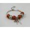 Pulsera de plata con cuentas naranjas y lazo