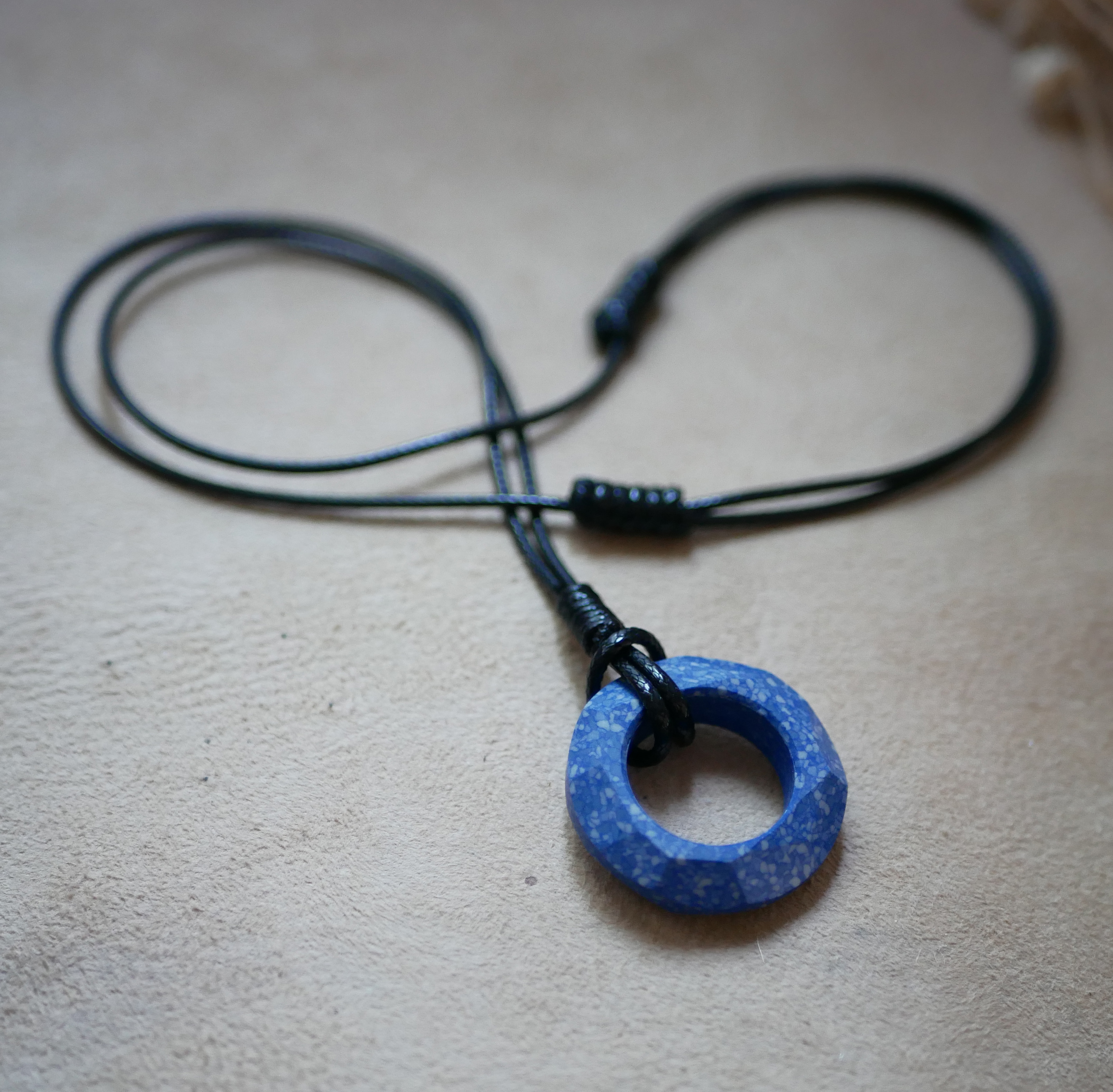 Collier anneau en céramique bleue sur cordon cuir noir ajustable